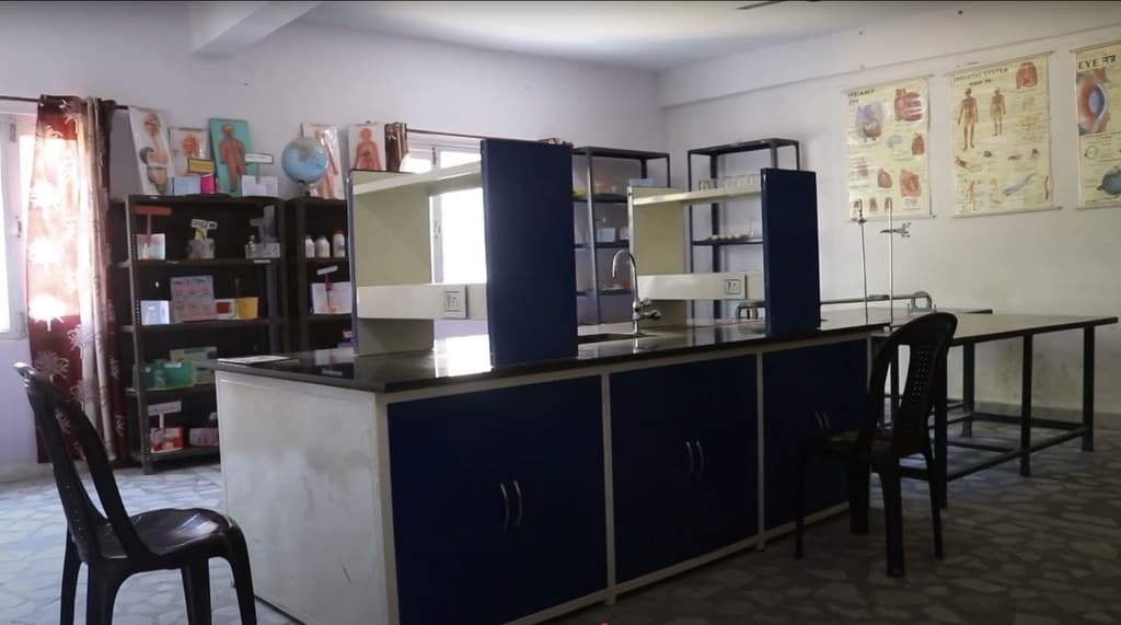 The chemistry laboratory, with workbenches, stools and science charts