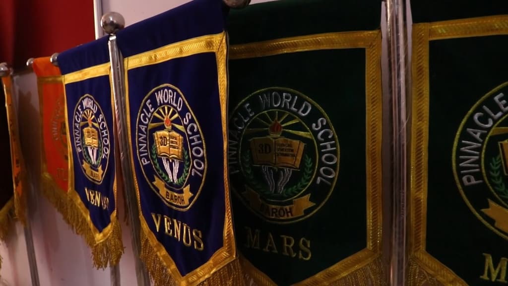 Embroidered house banners, including Venus and Mars, with the school emblem