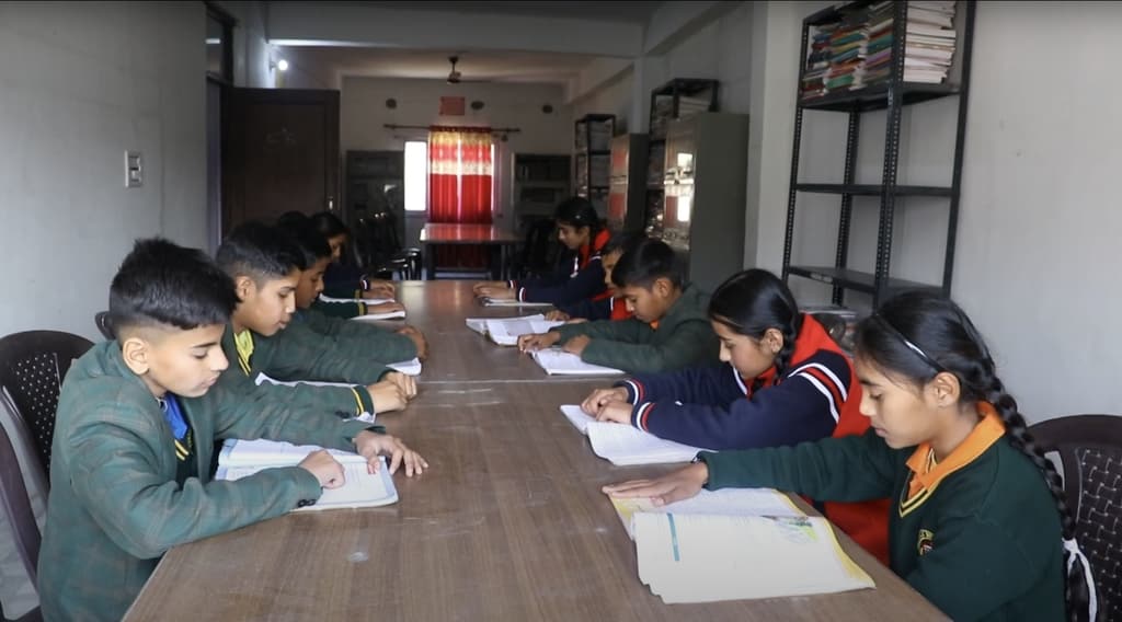 Students reading and writing at a long table in the school library