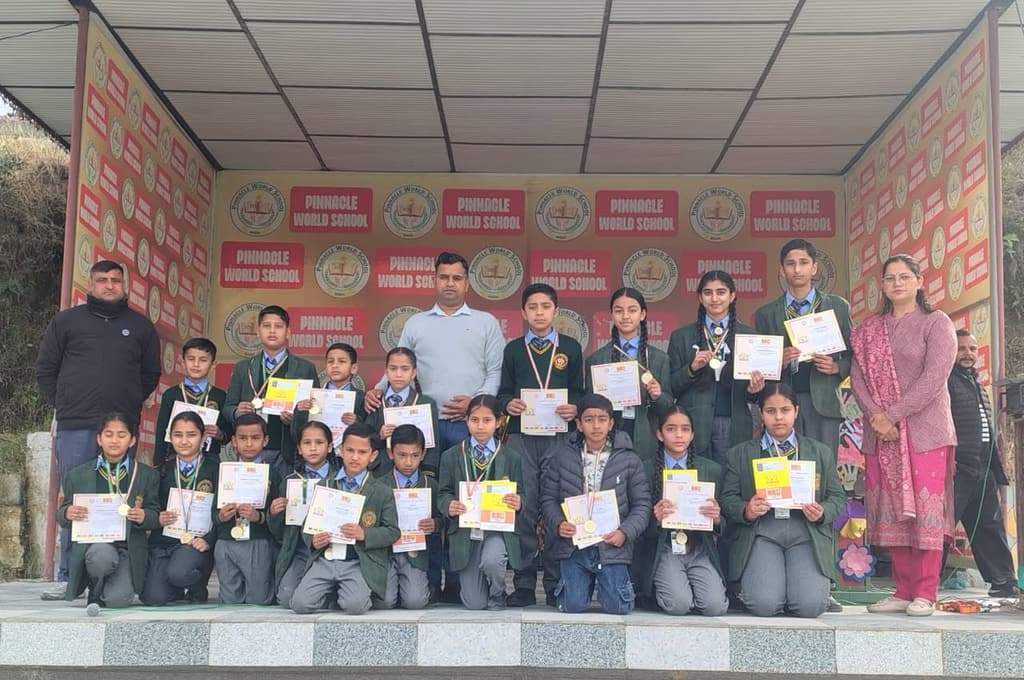 Students on the school stage holding their SOF International English Olympiad gold medals and certificates
