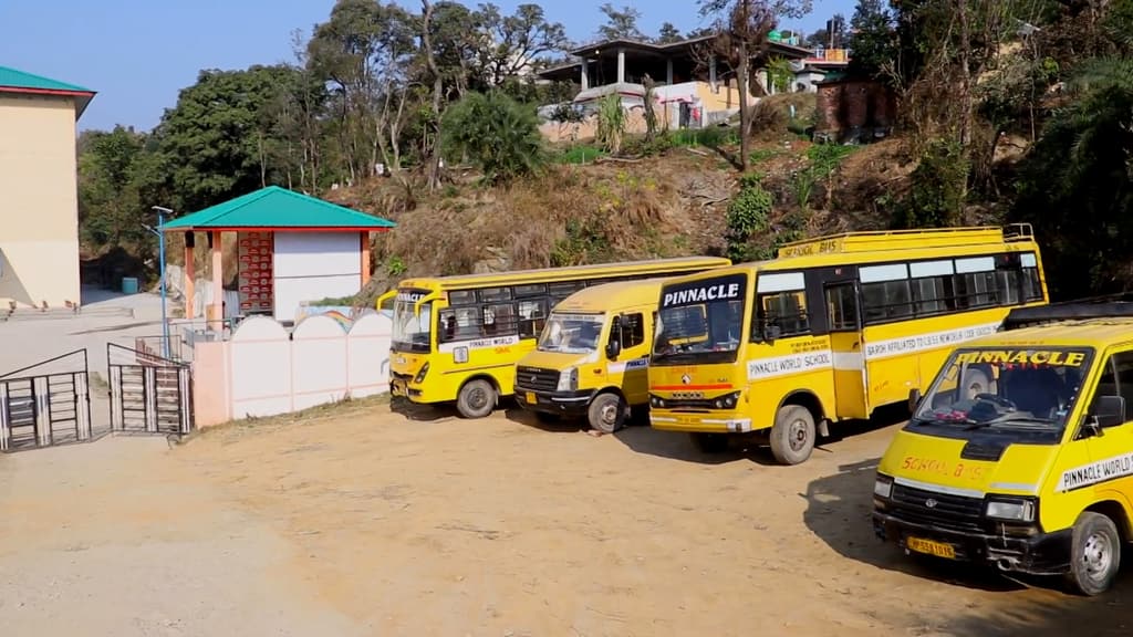 A row of yellow Pinnacle World School buses