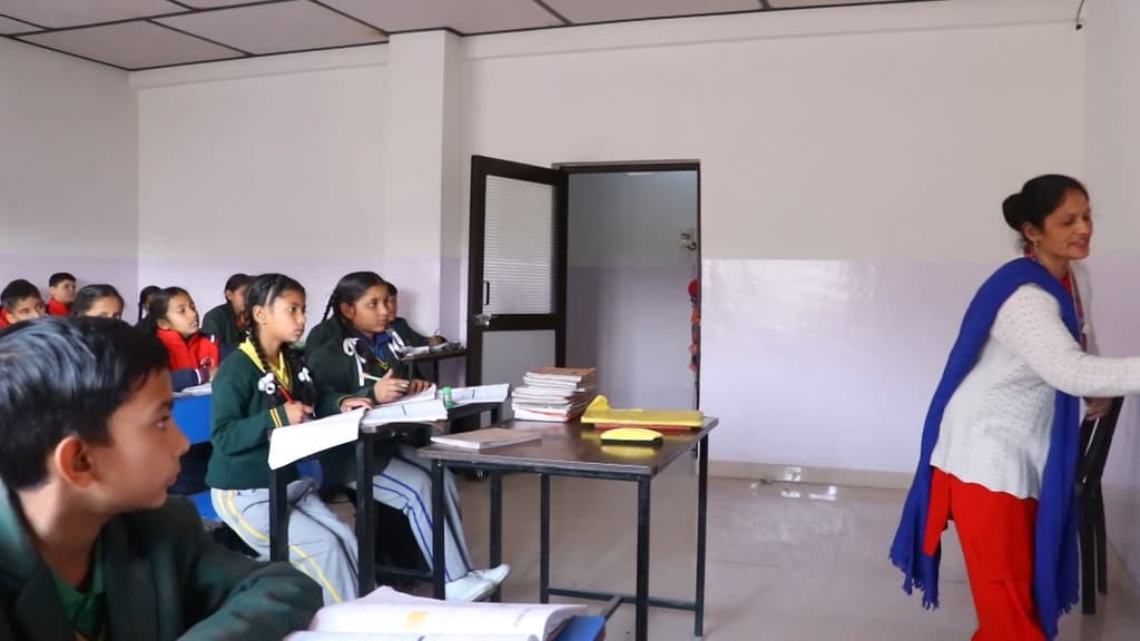 A teacher at the whiteboard in front of her class